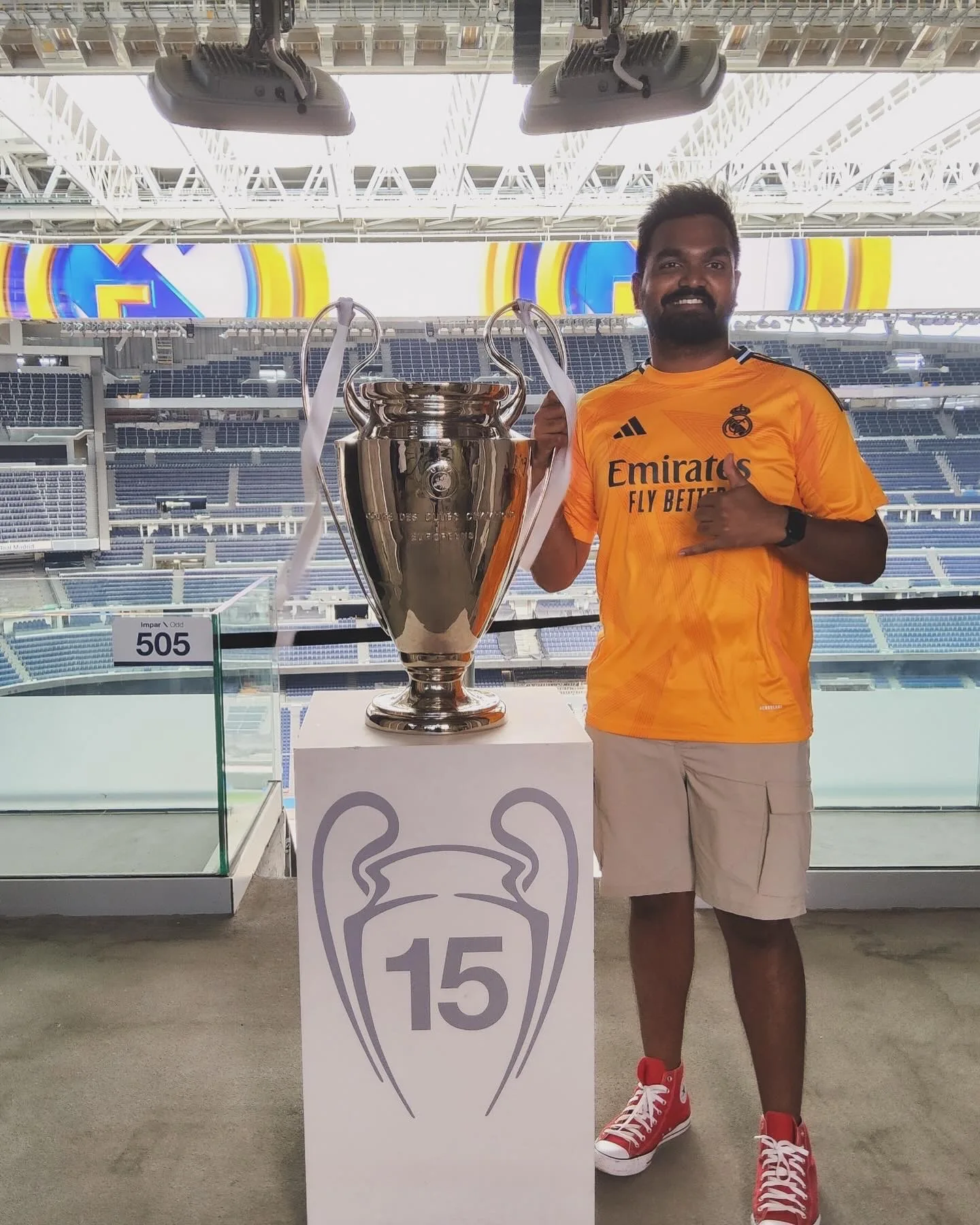 At a football stadium with a Champions League trophy